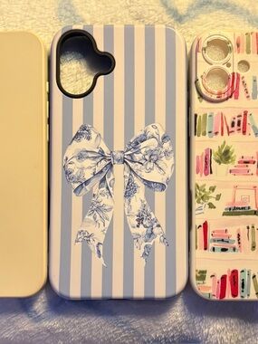 Three I Phone 16 Plus cases:  blue stripe with bow, bookshelves, & cream